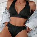 Women's pink halter strap bikini top and shorts swimsuit set on a mannequin.