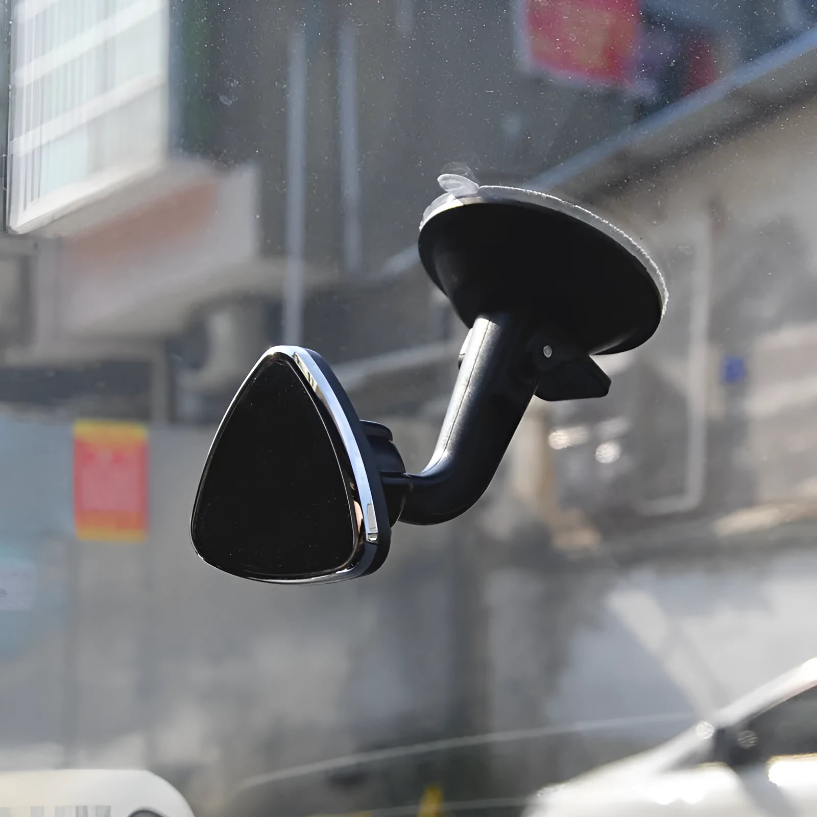 Black magnetic car phone holder mounted on dashboard with smartphone attached showing 360-degree rotation feature