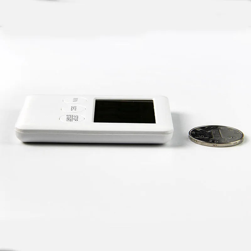 Black and white digital kitchen timer with magnetic back and LED display showing countdown time