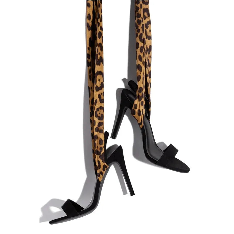 Light brown leopard print women's high heels with criss-cross ankle straps and a slim 8cm stiletto heel on a rubber sole.