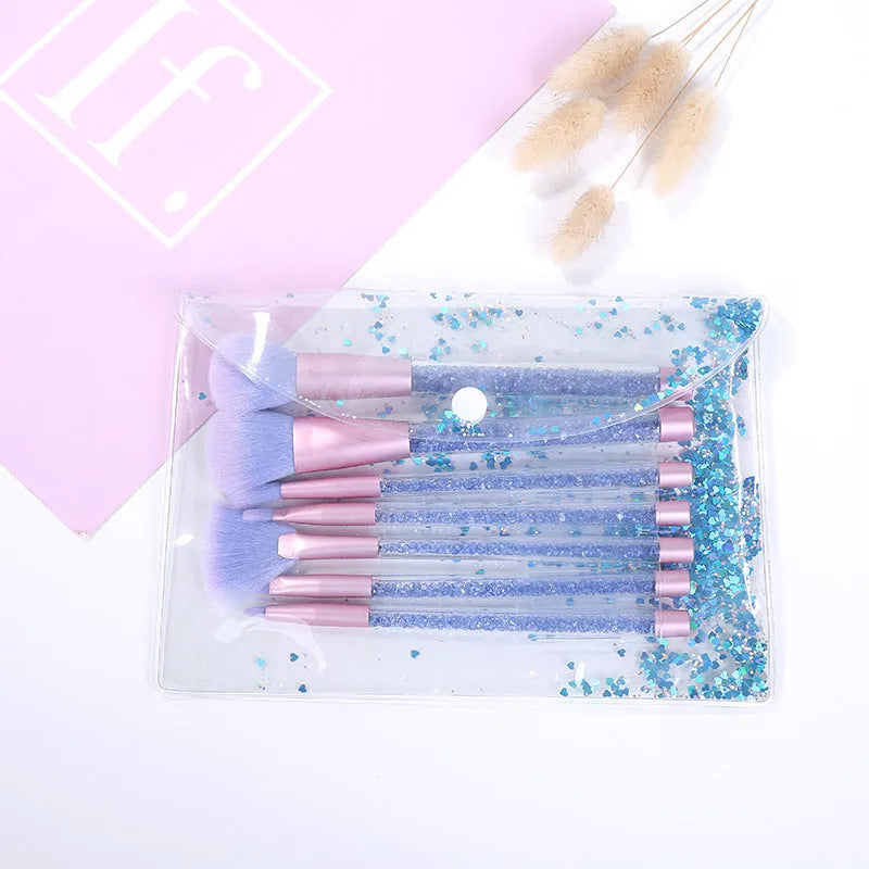 Set of 7 makeup brushes with pink handles, black bristles, and long plastic handles on a light background