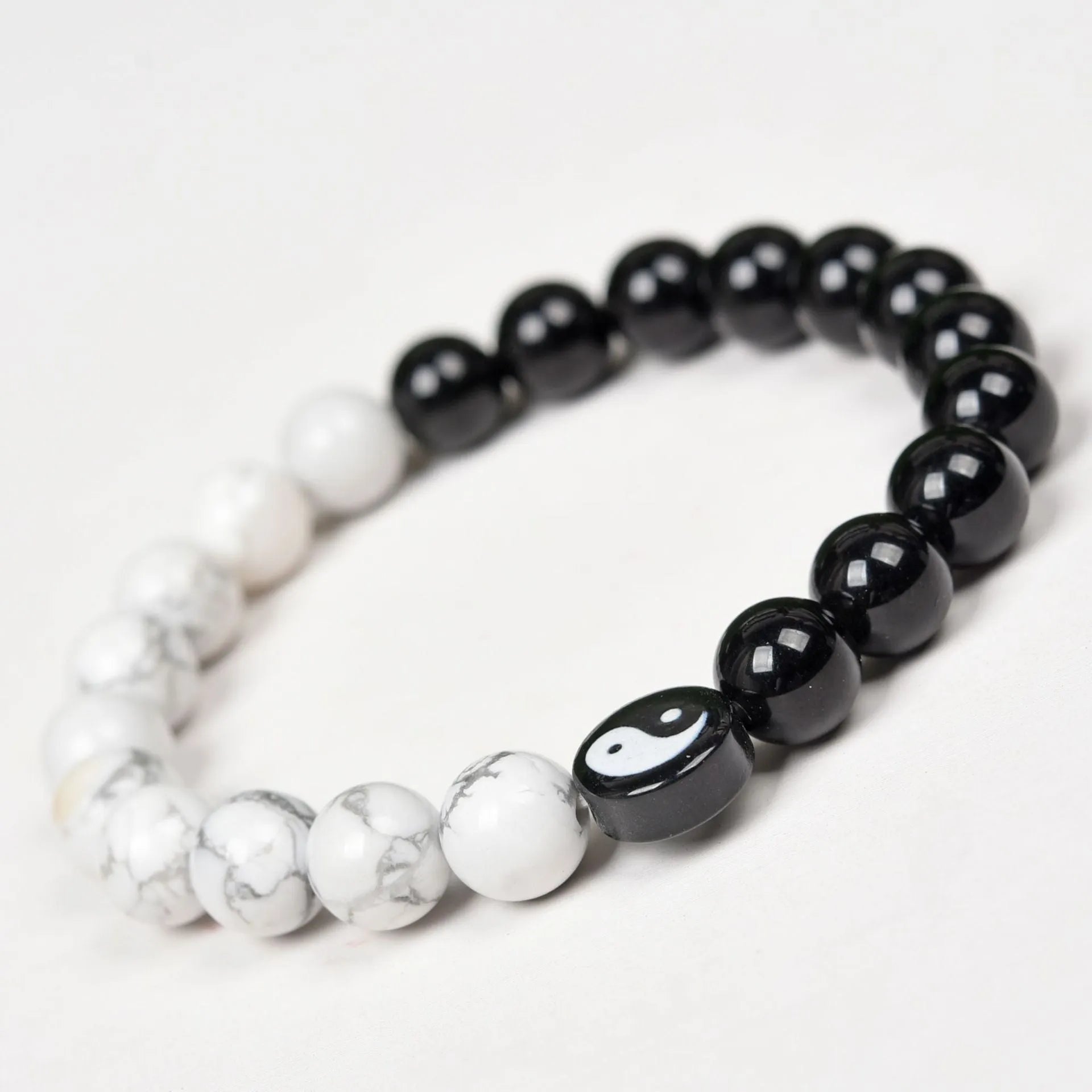 White turquoise and natural obsidian 8mm bead bracelet on a flat surface