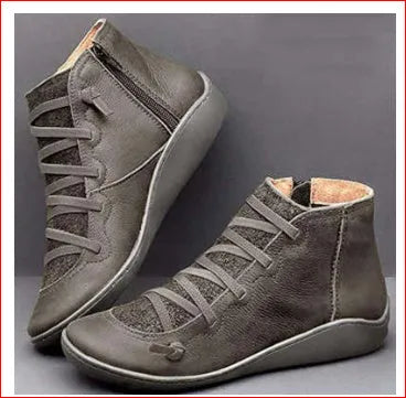 Women's flat ankle booties with a wedge heel, shown in multiple colours including black, leopard, and red.