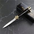 Damascus folding knife with 9.8cm blade and snake wood handle on outdoor wood surface