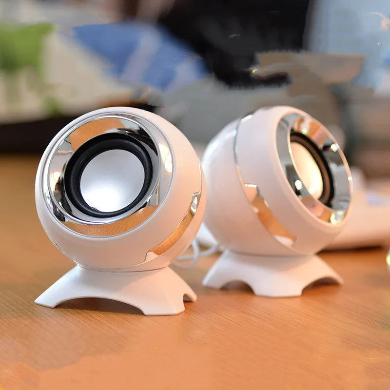 Black and gold USB-powered desktop computer speakers beside laptop showing compact 10cm dimensions