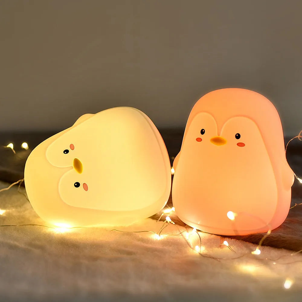 Penguin-shaped silicone and ABS night light with white LED glow, shown with USB charging cable.