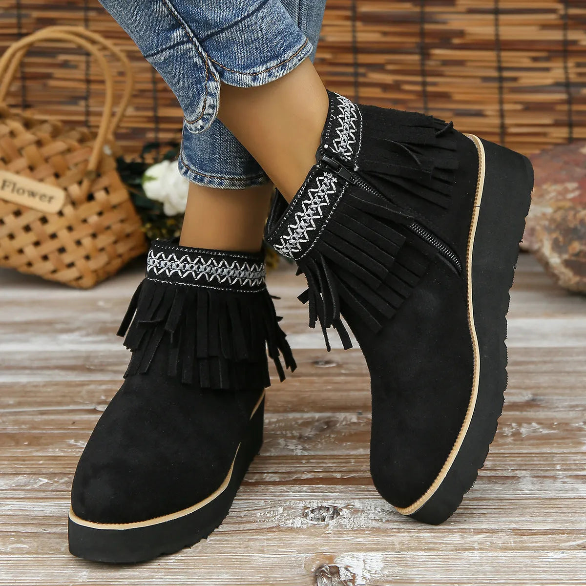 Women's black wedge bootie with suede upper, thick rubber sole, side zipper, and tassel detail.
