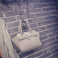 Women's PU messenger bag in black with zipper pocket and shoulder strap, top view with mini iPad inside.
