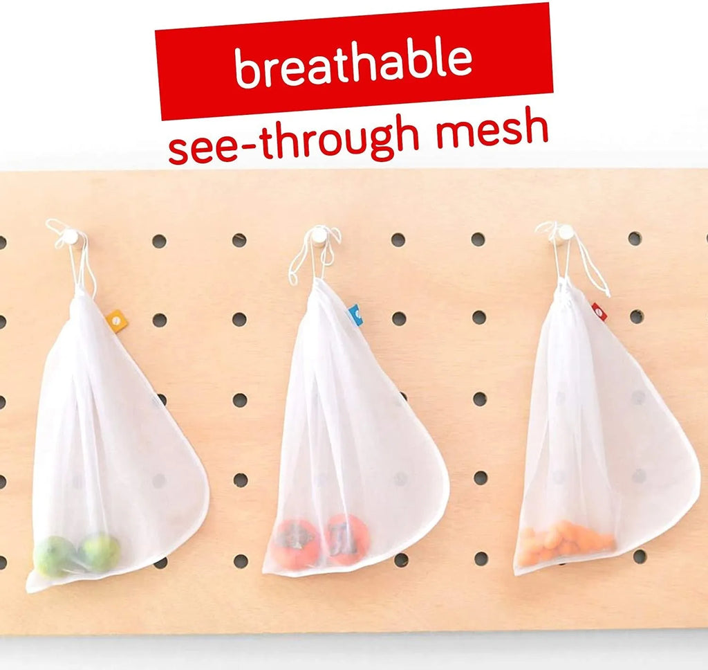 Five white cotton drawstring bags for kitchen vegetable storage arranged on a clean surface