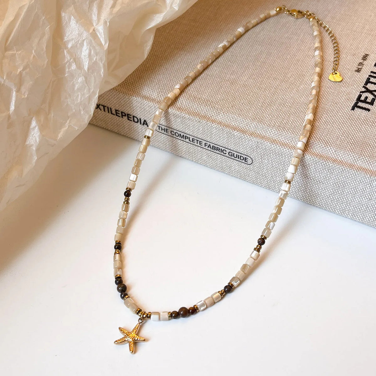 Titanium steel starfish pendant necklace with natural shell and tigereye beads on a 41-50cm chain.