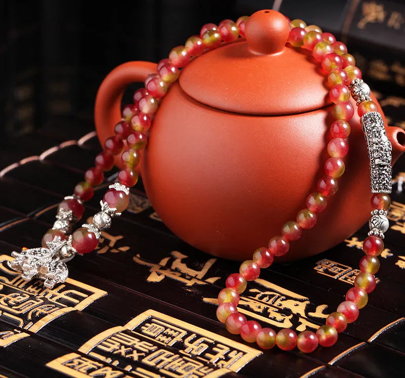 Handcrafted watermelon crystal bracelet with Chinese knot design showing 8mm elephant-style beads