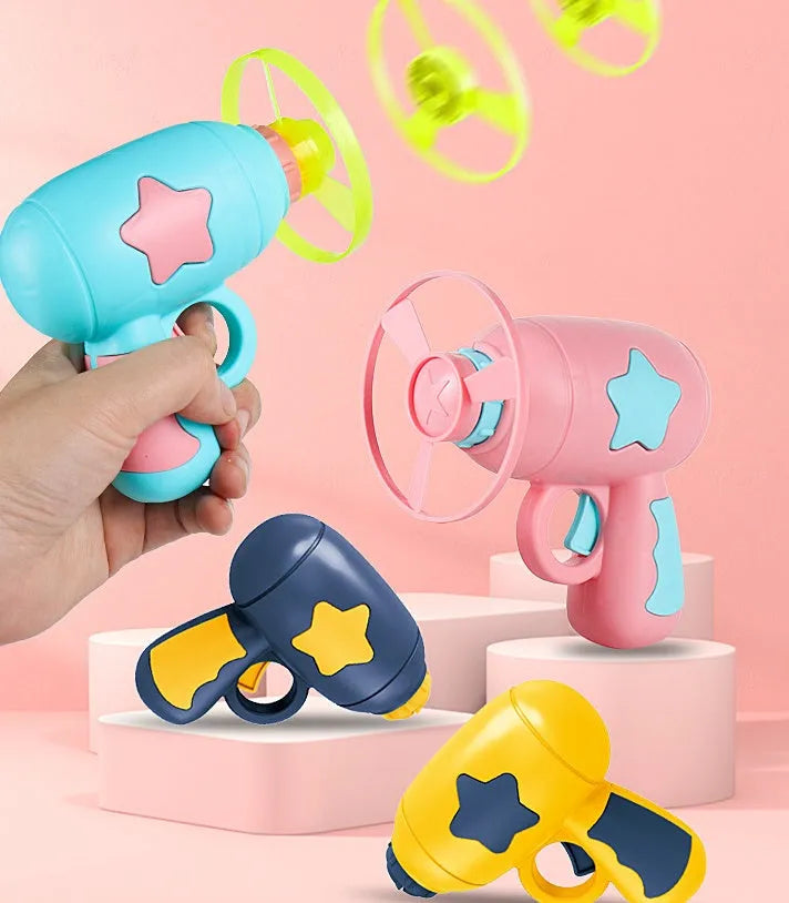 Blue plastic flying saucer launcher toy with LED-lit discs on a yellow target board.