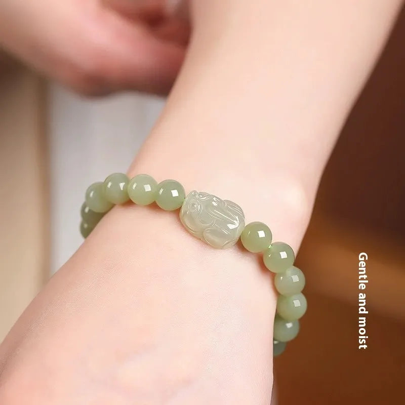 Grey Hetian jade ethnic style bracelet with polished beads on a wrist.