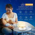 White touch control bedside night light with rechargeable battery and motion sensor on a table.