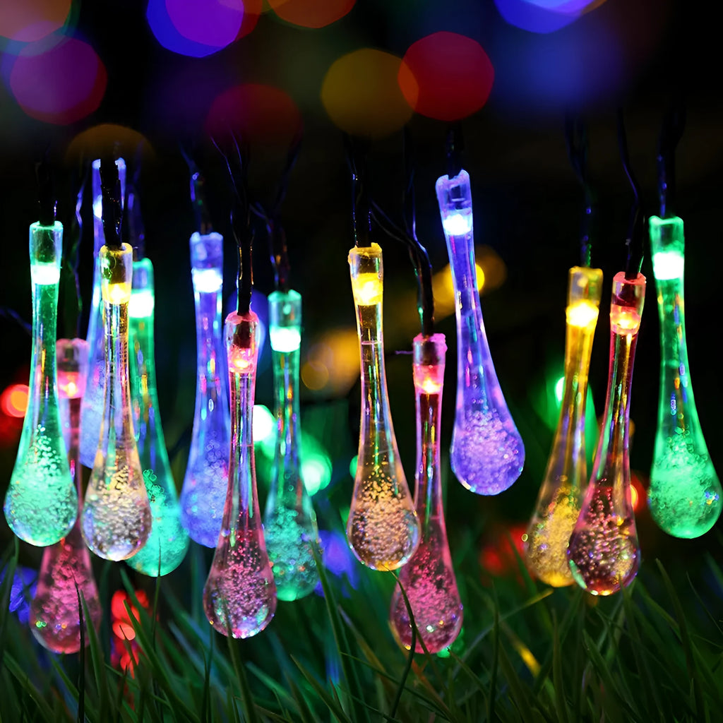 6.5 metre long solar-powered outdoor string lights with water drop shaped pendants on a green lawn.