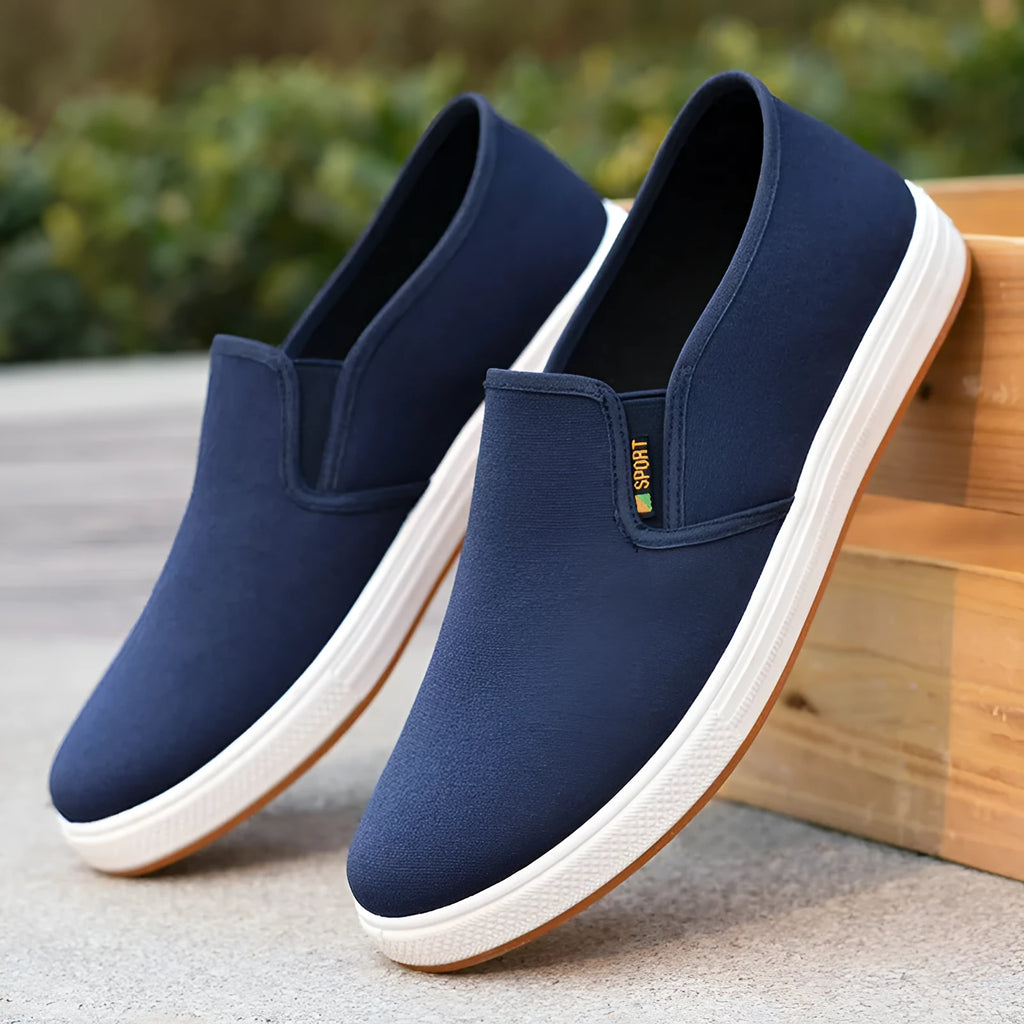 Men's low-top canvas slip-on shoes with rounded toe and injection moulded soles in black and blue colour options