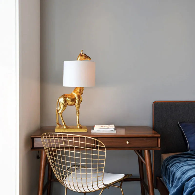 Giraffe table lamp with resin base and cloth shade, 66cm high, in white finish on a bedside table