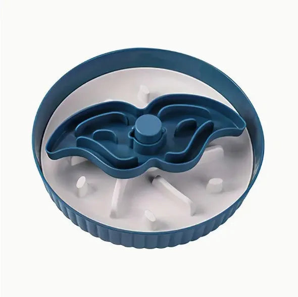 Rotating plastic pet feeding game board with blue silicone licking mat and a separate white bowl on a wooden table.