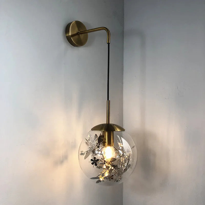 Modern creative wall-mounted bedside lamp with a golden flower glass shade and warm LED light.