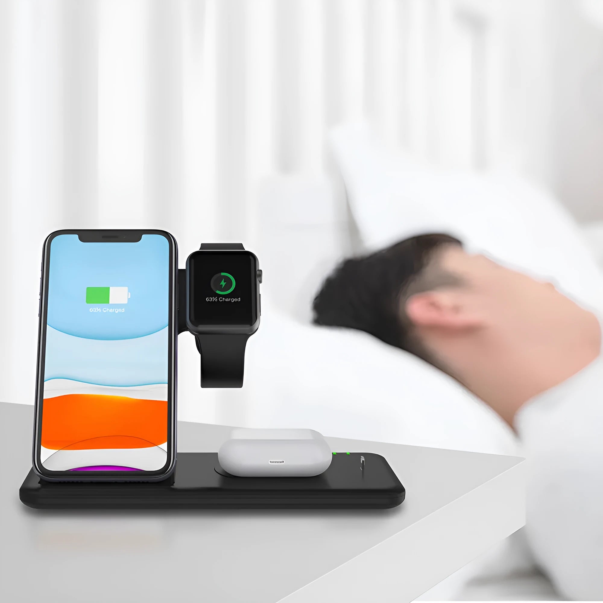 White three-in-one wireless charging stand for mobile phone, smartwatch, and headset on a desk.
