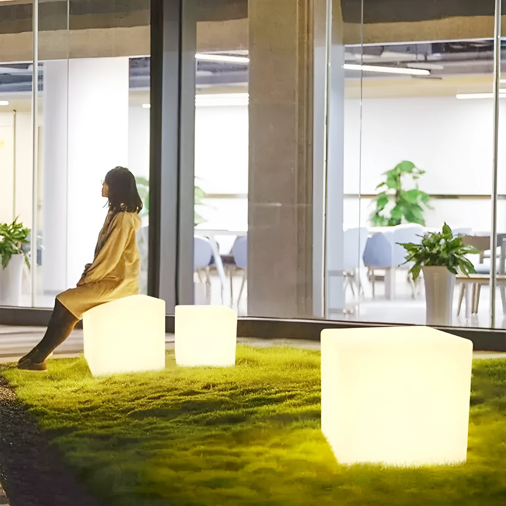 White square LED cube light stool on grass, showing modern design and waterproof build for outdoor use.