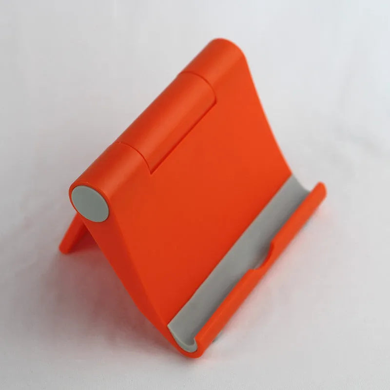 Anti-slip foldable phone holder with silicone pad in black, unfolded on a desk