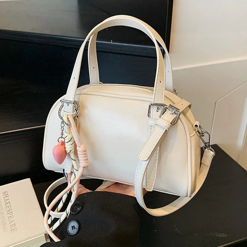 Soft black PU leather Korean-style shell-shaped women's shoulder bag with a pendant.