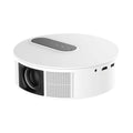 White HD home theatre projector with remote control on a wooden table.