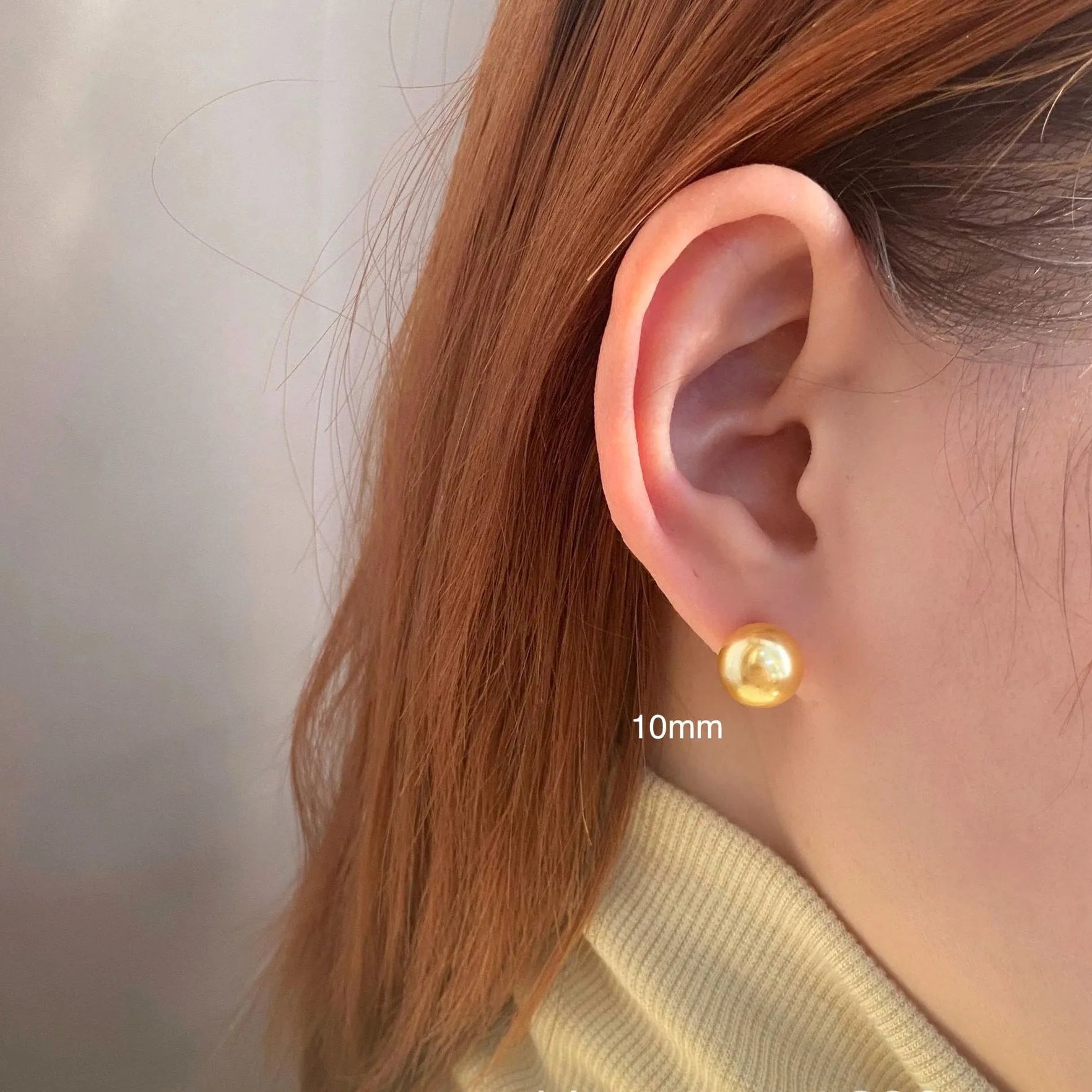 A pair of large pearl stud earrings with a geometric silver setting and an eight-pointed star detail on a white background.