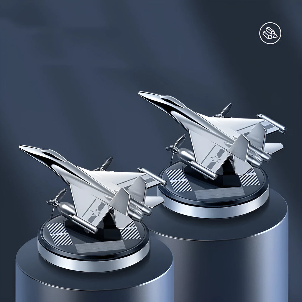 Solar powered rotating silver fighter jet car air freshener ornament on a dashboard.