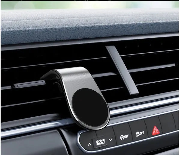 Black universal car phone holder bracket mounted on a car dashboard holding a smartphone.
