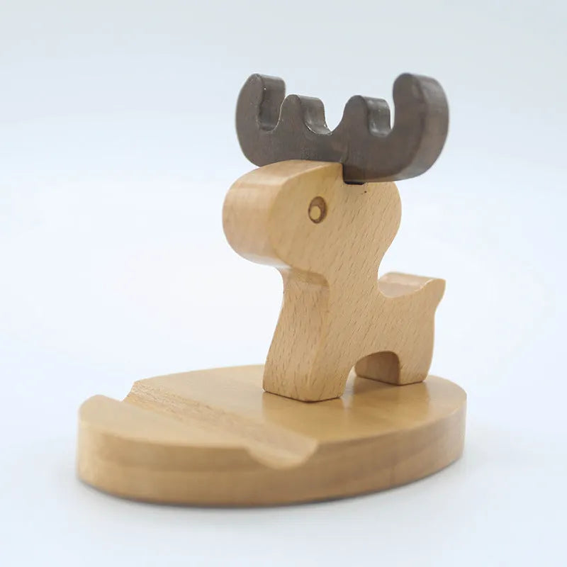 Solid beech wood phone stand with a decorative resin puppy figurine, holding a mobile phone at an angle with a charging cable threaded through the back.