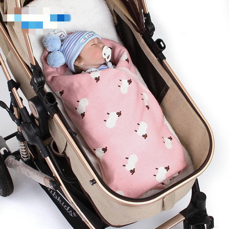 Grey 100% cotton baby blanket cover draped over a sheepskin rug in a pram.