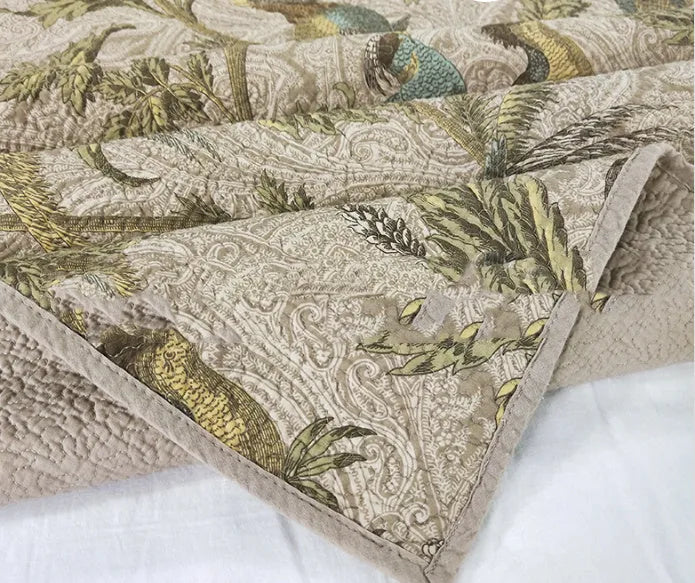Blue American floral and bird pattern quilted cotton bedspread set on a bed