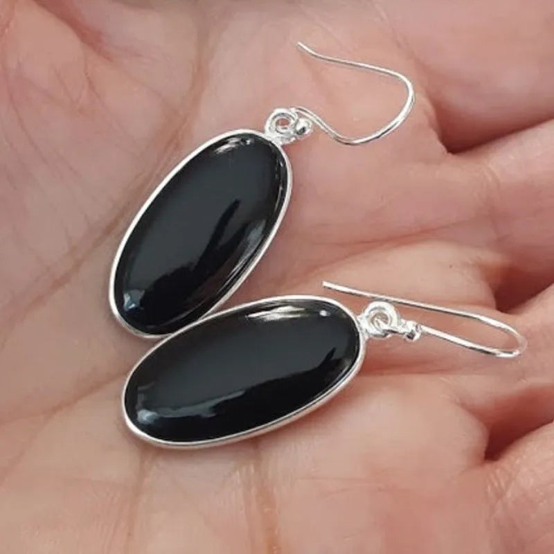 A pair of women's geometric earrings with a black agate oval pendant on alloy settings.