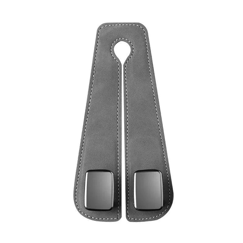 Black car seat hook with suede padding and flip-back design mounted on a grey car seat