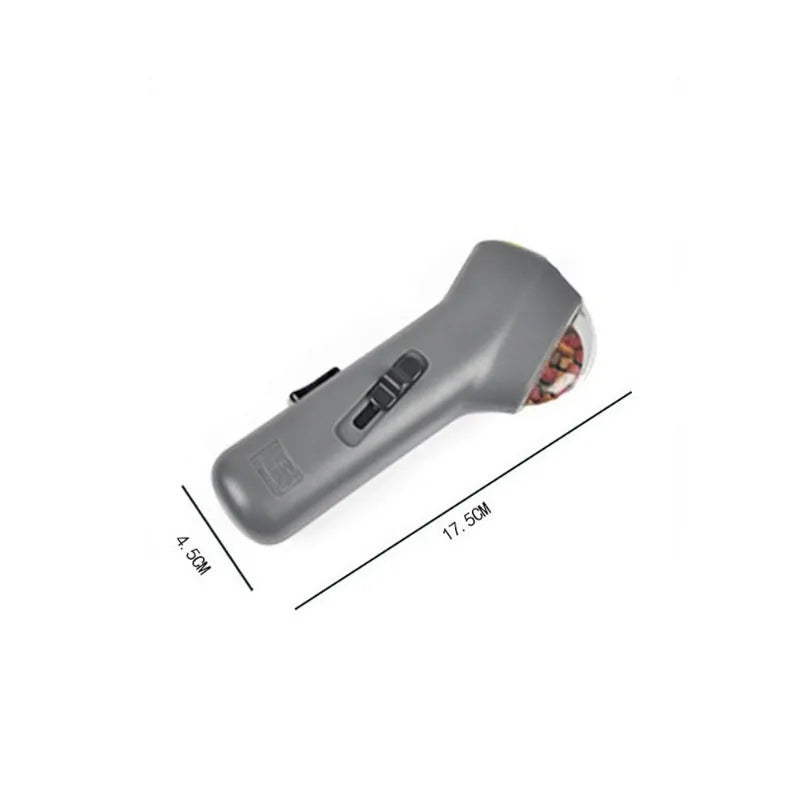 Grey pet snack catapult launcher for dog and cat training, showing handle and treat compartment