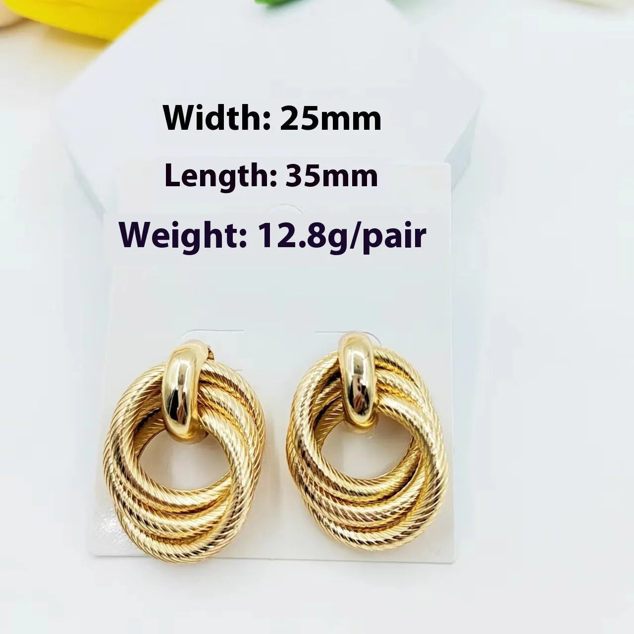 Gold geometric ring embossed twisted stud earrings on white background