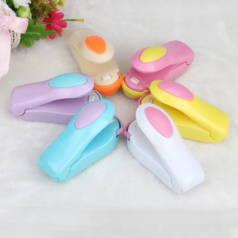 Mini hand pressure heat sealing machine in blue on white background, 10cm long ABS and metal body