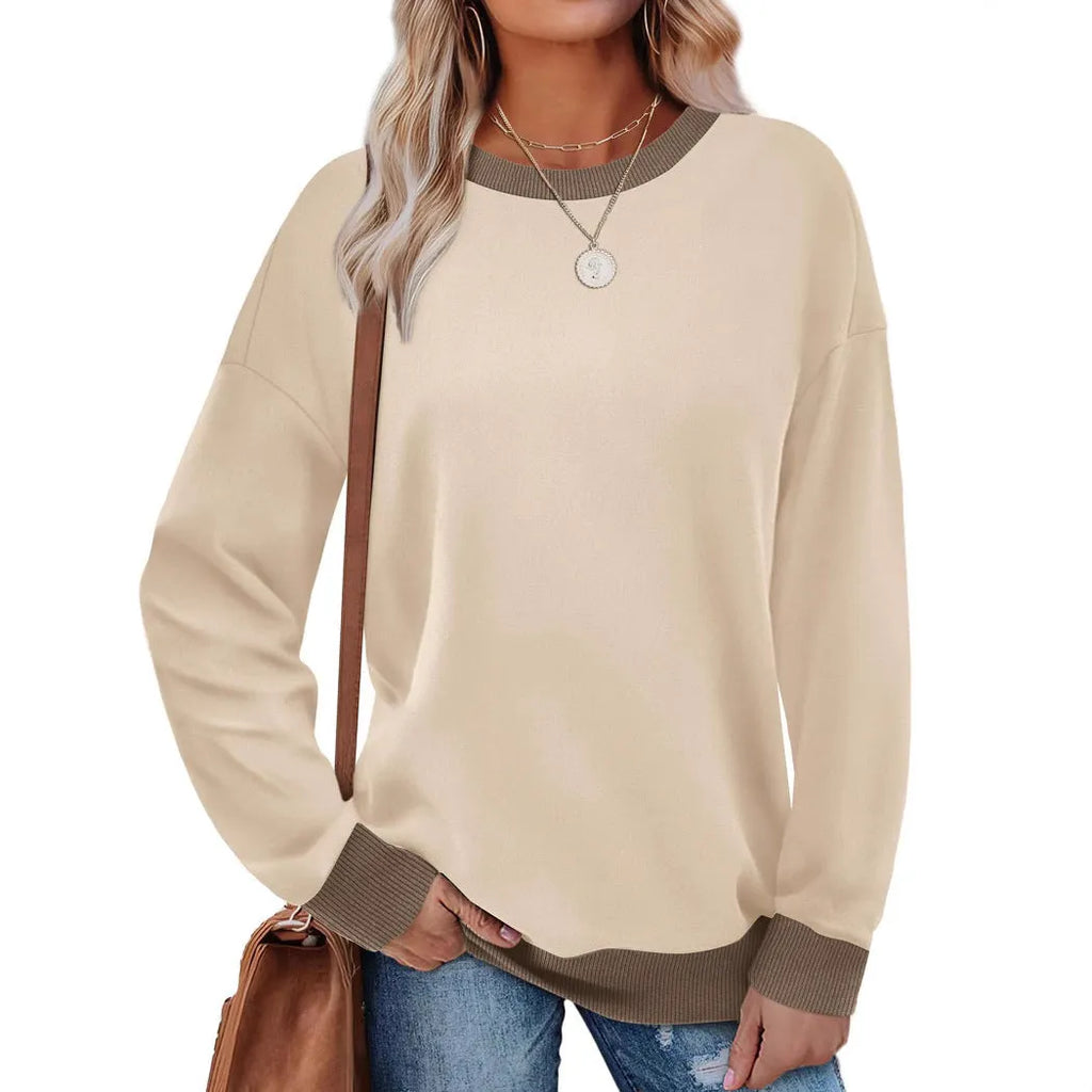A woman wearing a loose-fitting striped long-sleeved top with a round neck in a grey colour.