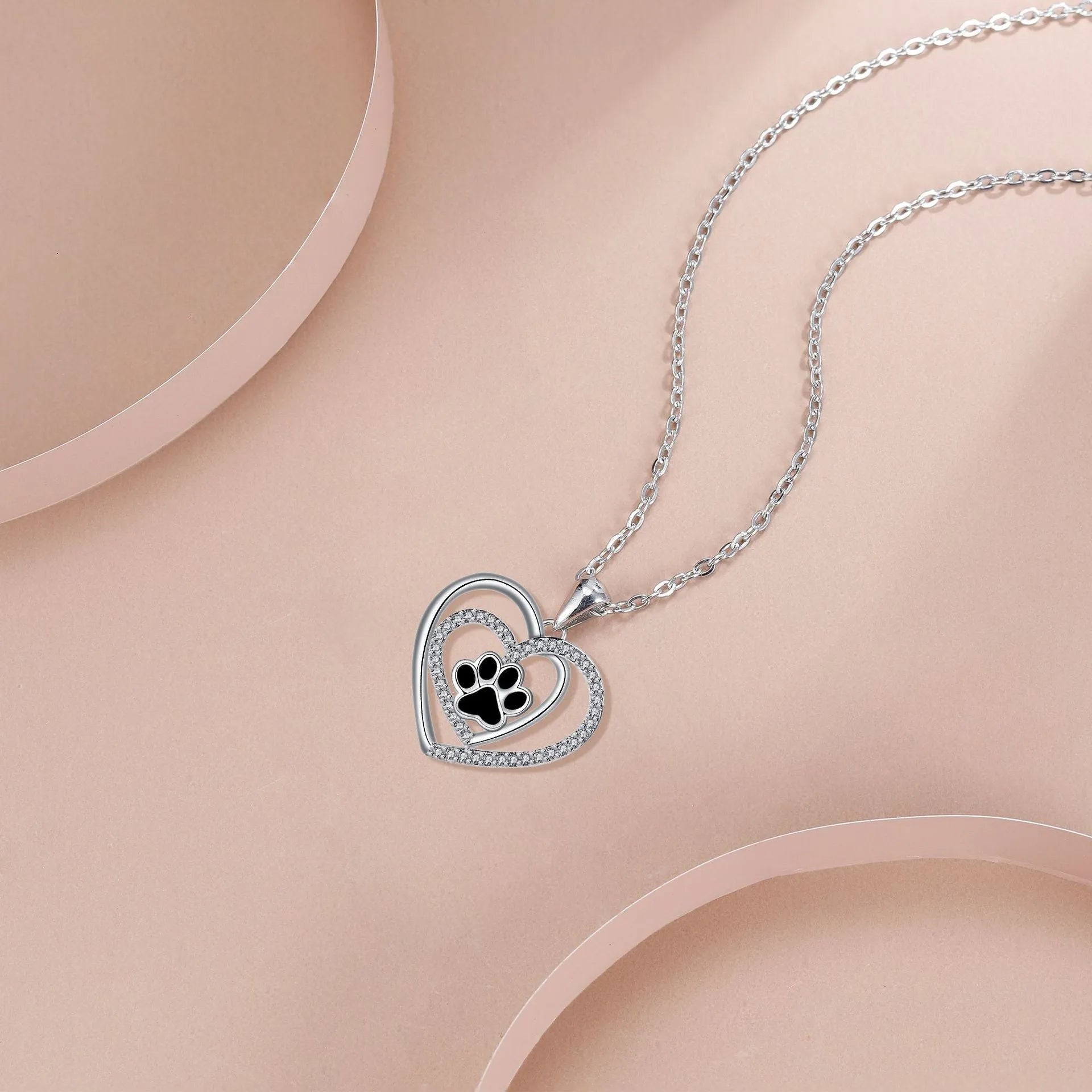 Women's copper necklace with dog paw print and heart detail pendant on cross chain.
