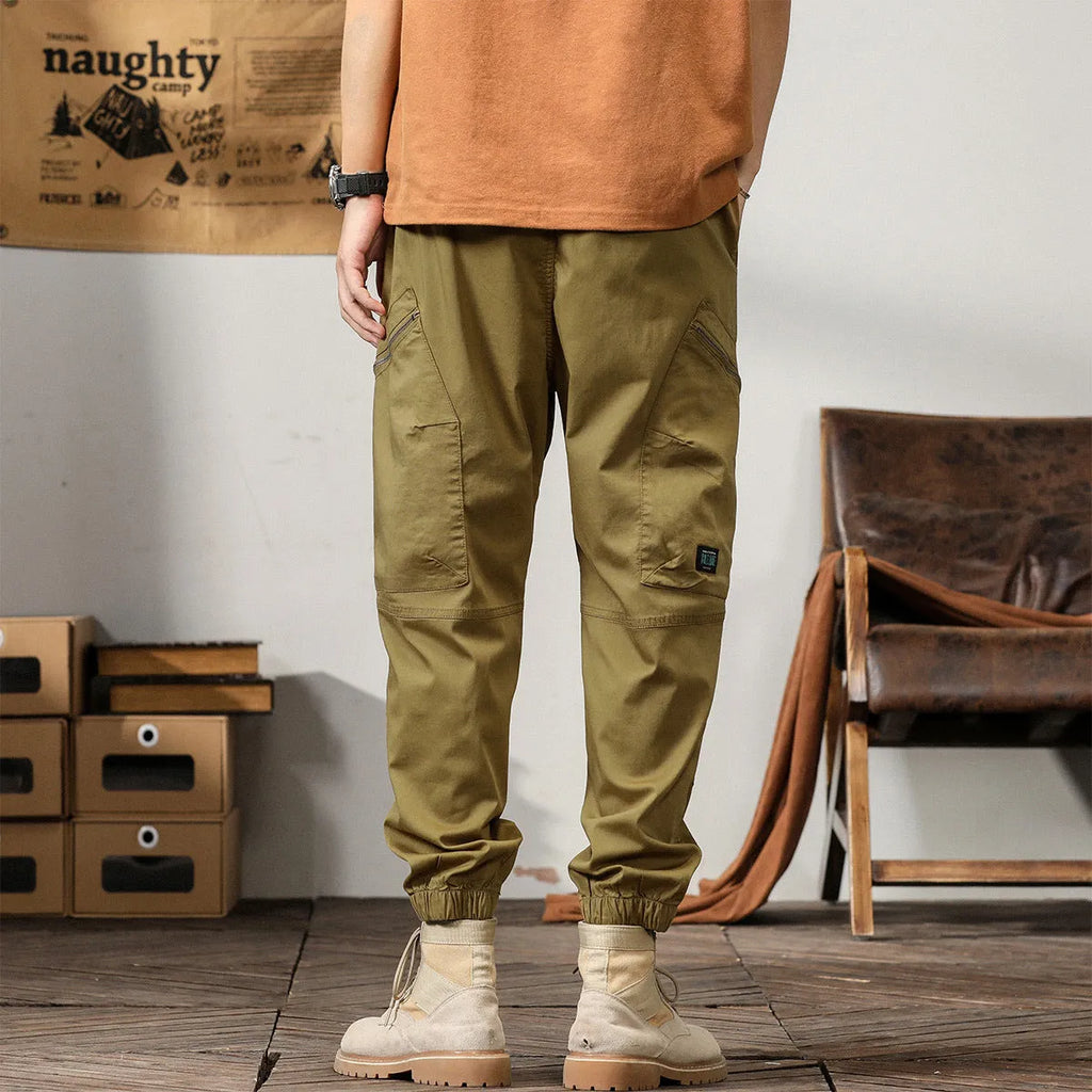 Men's khaki cotton harem pants with ankle bands and a loose, tapered fit.
