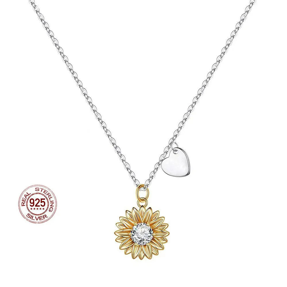 Silver sunflower necklace with geometric pendant and cross chain on a model.