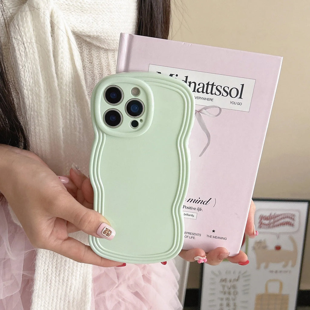 Glossy iPhone case with a soft cream and candy-colour wave pattern on a pink background.