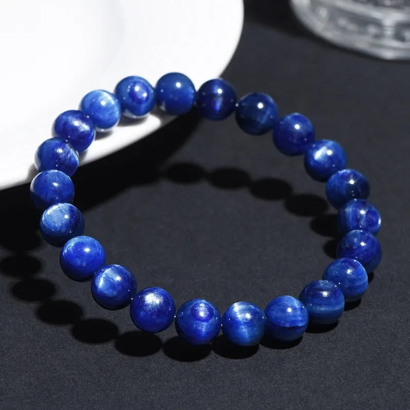 Blue crystal ball bracelet with geometric beads and a Ruyi charm on a white background.