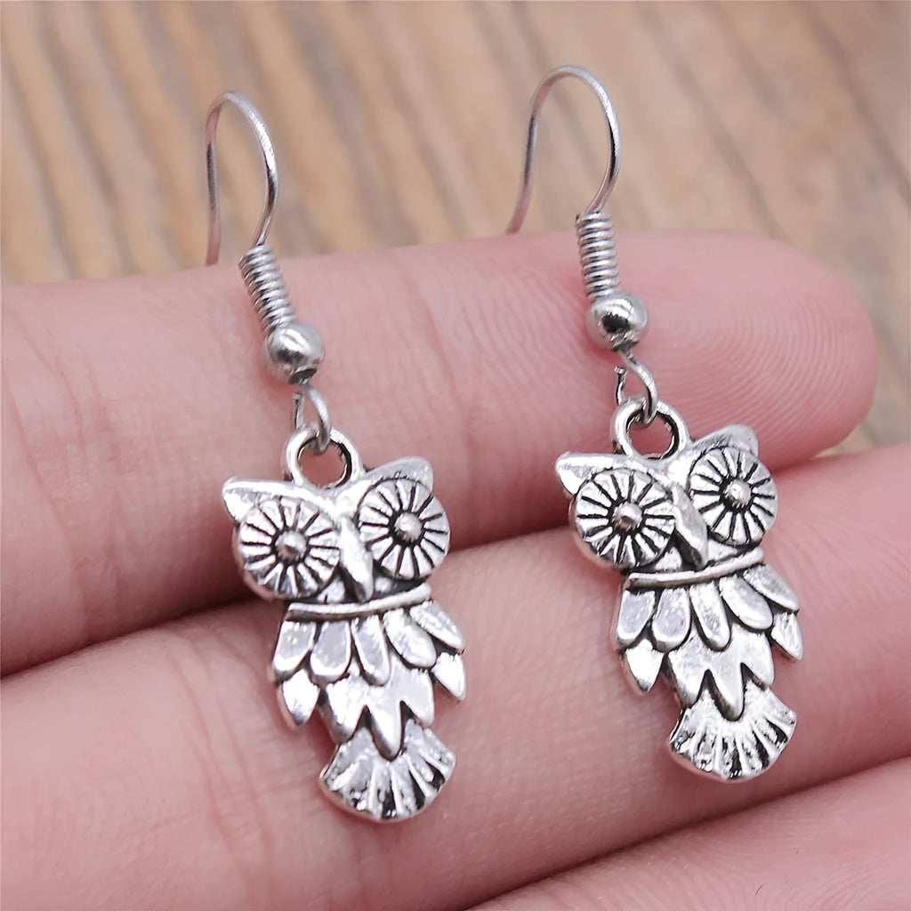 Retro minimalist handmade owl drop earrings in Antique Silver metal finish on a light background