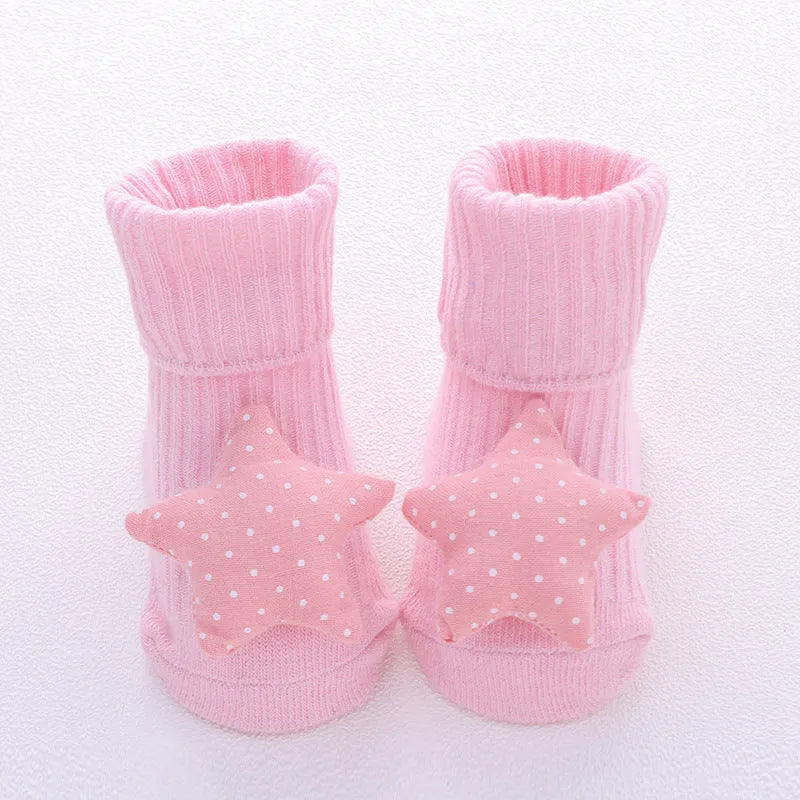 Cotton baby floor socks in various colours and patterns including pink bows, grey stars, and panda design.