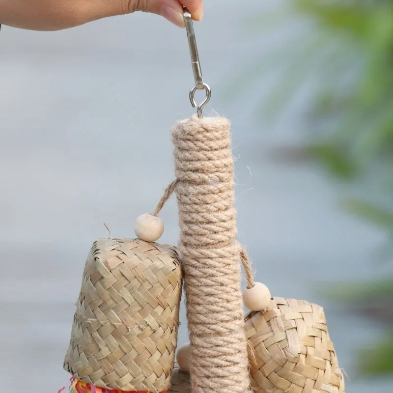 A parrot toy made of wood and sisal rope with colourful shredded paper attachments.