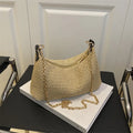 Khaki woven straw crossbody handbag with square shape and crossbody strap.