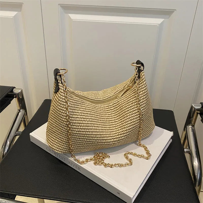 Khaki woven straw crossbody handbag with square shape and crossbody strap.